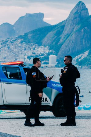 Photo for Rio de Janeiro, Brazil - December 27th, 2022: Police watch over tourists in Arpoador, Rio de Janeiro, Brazil. Rio is a popular tourist city but also experiences high levels of crime - Royalty Free Image