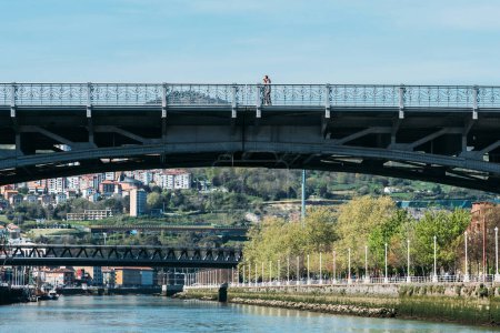 Téléchargez les photos : Bilbao, Espagne - 7 avril 2023 : Vue des piétons traversant le pont Deustuko Zubia sur la rivière Nerion à Bilbao, Espagne - en image libre de droit
