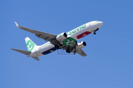 Photo for Lisbon, Portugal - July 12, 2023: Dutch based Transavia air company with aircraft Boeing 737-8GJ approaching to land at Lisbon International Airport against blue sky - Royalty Free Image