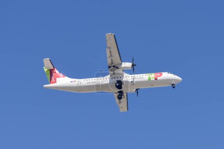 Foto de Lisboa, Portugal - 12 de julio de 2023: Compañía portuguesa Tap con aviones ATR 72-600 acercándose a aterrizar en el Aeropuerto Internacional de Lisboa contra el cielo azul - Imagen libre de derechos
