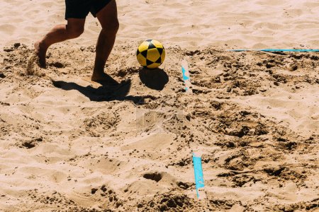 Photo for Close up of unidentifiable man playing Footvolley on the beach on a sunny summer day - Royalty Free Image