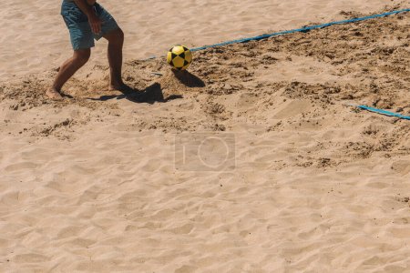 Photo for Close up of unidentifiable man playing Footvolley on the beach on a sunny summer day - Royalty Free Image