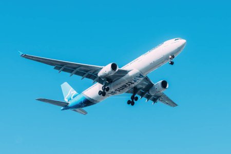 Foto de Lisboa, Portugal - 18 de julio de 2023: La compañía aérea canadiense Air Transat con Airbus A330 se acerca a aterrizar en el Aeropuerto Internacional de Lisboa contra el cielo azul - Imagen libre de derechos