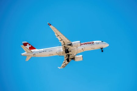 Foto de Lisboa, Portugal - 31 de julio de 2021: Avión de Swiss International Air Lines Airbus A220-300 AG contra el cielo azul - Imagen libre de derechos