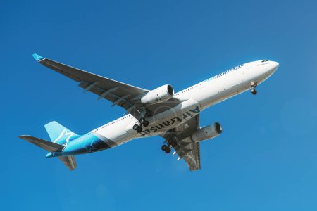 Foto de Lisboa, Portugal - 27 de agosto de 2023: La compañía aérea canadiense Air Transat con Airbus A330 se aproxima para aterrizar en el Aeropuerto Internacional de Lisboa contra el cielo azul - Imagen libre de derechos