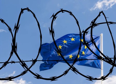 Foto de Bandera de la Unión Europea contra un cielo azul superpuesto con alambre de púas en relación con un bloque potencialmente cerrado a ciudadanos de terceros países, incluidos los refugiados - Imagen libre de derechos
