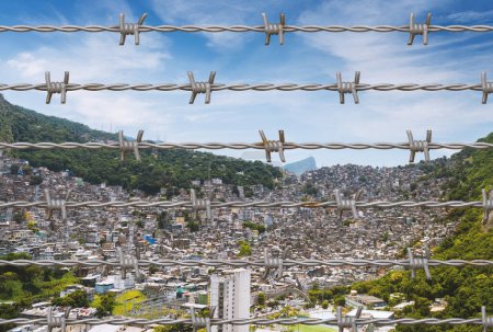 Photo for Aerial panoramic view of a Rocinha favela in Sao Conrado, Rio de Janeiro, Brazil, home to roughly 70,000 inhabitants superimposed with barbed wire - Royalty Free Image