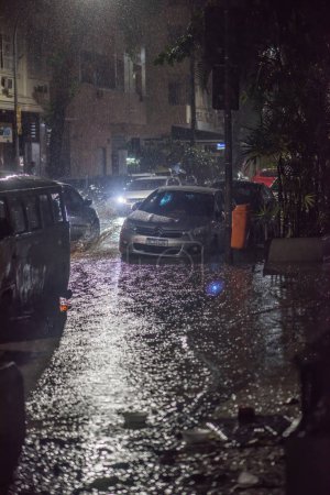 Téléchargez les photos : Rio de Janeiro, Brésil - 21 janvier 2024 : Conséquences de fortes tempêtes tropicales avec des rues inondées, des arbres abattus et des lignes électriques la nuit à Rio de Janeiro, Brésil - en image libre de droit
