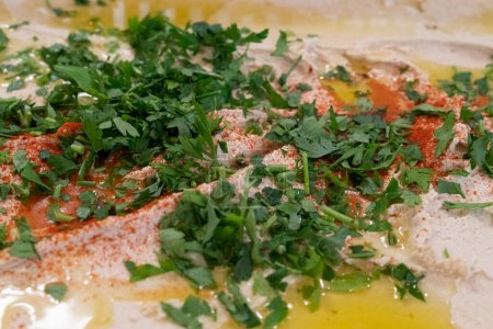 Foto de Hummus hecho a mano con cilantro y aceite de oliva para catering - Imagen libre de derechos