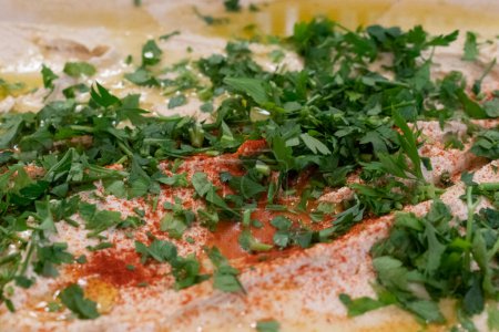 Foto de Hummus hecho a mano con cilantro y aceite de oliva para catering - Imagen libre de derechos