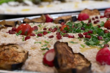 Photo for Fresh Tehina spread with pomegranate seeds , olive oil and coriander and grilled aubergine - Royalty Free Image