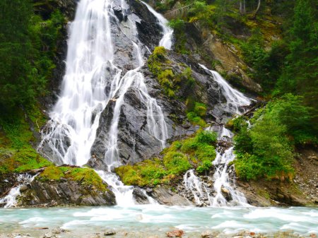 Waterfall Schleierwasserfall in the Osttirol region on a summer rainy day. Lush green vegetation.  Alps, Austria. 