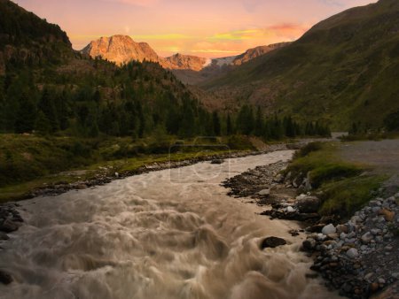 El arroyo en el valle Kaunertal por la tarde veraniega, las montañas, el cielo, las nubes. Alpes, Austria. Procesamiento creativo posterior. 