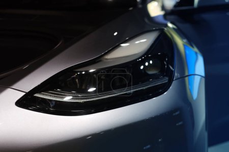 Foto de Visión frontal luces delanteras de xenón avanzadas del coche Tesla modelo Y en plata líquida, Mercurio Plata Color metálico, popular vehículo eléctrico de pasajeros en el showroom, Elon Musk, Frankfurt - diciembre 2022 - Imagen libre de derechos