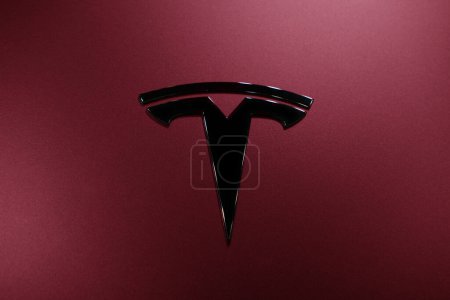 Photo for Closeup chromium-plated Logotype Tesla Motors on red hood, Deep Crimson Multicoat, most popular passenger electric car in world, Elon Musk, electric vehicle production, Frankfurt - December 2022 - Royalty Free Image