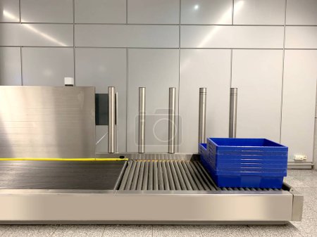 Photo for Plastic containers for gadgets, hand luggage, bags rides along conveyor to be checked by airport security personnel, boxes on way to X-ray machine airport checkpoint, air travel security requirement - Royalty Free Image