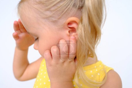 Foto de Oído pequeño paciente, niño, niña de 3 años, parte de la cara en el perfil de primer plano, concepto médico, control de la audición, inflamación del oído medio, otitis media, diagnóstico y tratamiento de oftalmología, enfermedades del oído - Imagen libre de derechos