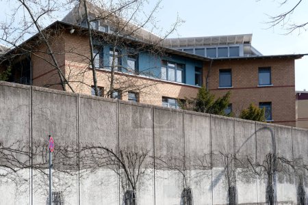 Foto de Cerca de hormigón alto, cerca de alambre de púas en la parte superior, celda de detención preventiva, edificio para la ejecución de castigos para los delincuentes, prisión de mujeres de Frankfurt, desesperanza de cautiverio - Imagen libre de derechos