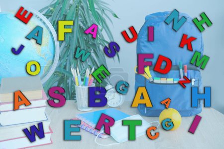Photo for Scattering of multi-colored different letters against school stuff background, speech disorders, dyslexia awareness, help children with reading, learning difficulties, human brain development concept - Royalty Free Image