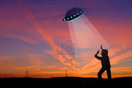 Photo for Black silhouette of ufo spaceship, man, earthling in rays of light, dramatic, disturbing situation, concept aliens arrived on flying saucer, mysterious disappearance of people, paranormal phenomena - Royalty Free Image