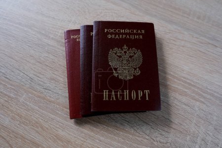 Photo for Foreign International biometric passports, passport of citizen of Russian Federation with red cover, personal document, internal passport on wooden table, bureaucracy concept, renunciation citizenship - Royalty Free Image