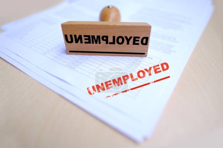 Photo for Unemployed red rectangular grunge sign on documents, red text on white, Wooden vintage hand rubber stamp, concept of becoming unemployed, layoffs to reduce staff of enterprise, fear of poverty - Royalty Free Image