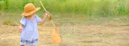 Photo for Child 3 years old, girl in straw hat with entomological insect net catches butterflies and dragonflies to explore nature, concept of young entomologist, naturalist, preschoolers' interest in nature - Royalty Free Image