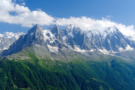 Foto de Altas montañas, acantilados rocosos con árboles, en el fondo se pueden ver los Alpes franceses con el nevado Mont Blanc, el concepto de senderismo, escalada, estilo de vida activo, belleza de la naturaleza - Imagen libre de derechos