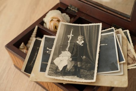 stack of old retro family sepia photos on table, vintage wooden box with dear heart memorabilia, concept of family tree, genealogy, memory of ancestors, home archive, childhood memories