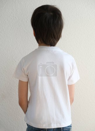 Foto de Espalda de niño, niño de 10 años, maqueta vacía, en blanco en camiseta blanca está de pie, buena postura, espalda recta, prevención de la escoliosis en la infancia, concepto de salud, fortalecimiento de la columna vertebral - Imagen libre de derechos