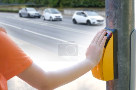 niño, niño 9-10 años presiona botón amarillo cruce peatonal para encender semáforo luz verde para cruzar la calle de la ciudad, concepto de estudiante de primaria, calle borrosa, paisaje urbano