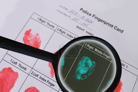 Photo for Magnifying glass in hand of criminal expert, forensic specialist, detective, police fingerprint card with fingerprints, investigation of crime, identification of criminal, scientific fingerprinting - Royalty Free Image