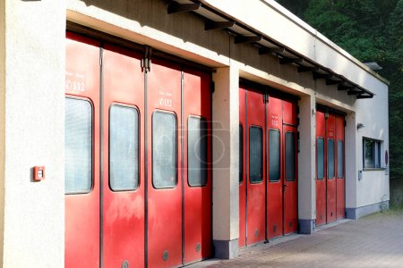 row of vintage red retro fire station doors in vintage style, fire assistance on German, duty dispatcher, fire trucks and other fire equipment, emergency services vehicle, Frankfurt, Germany