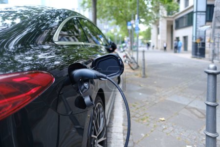 PKW-Elektroauto füllt Batterie-Ladestation auf, Konzept der Entwicklung alternativer Energien, Produktion von Elektrofahrzeugen, saubere Energie, Innovation von Elektrofahrzeugen, Ökologie der Städte