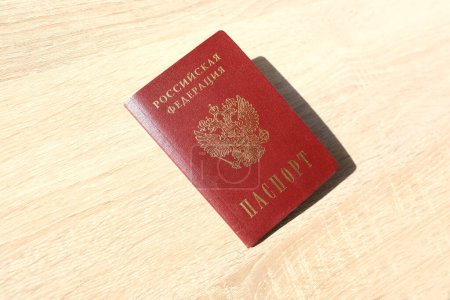 Téléchargez les photos : Passeport du citoyen Fédération de Russie sur une table en bois léger, le concept d'obtention d'un visa, Voyage, l'obtention de la citoyenneté, le respect des droits et libertés civiles - en image libre de droit