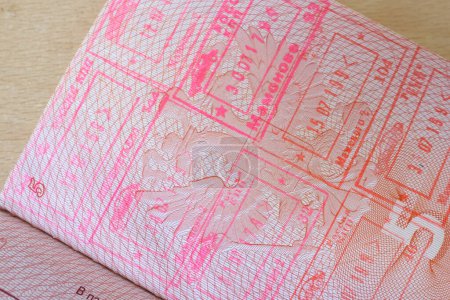Photo for Close up part of pages of foreign passport with foreign visas, border stamps, permits to enter countries, concept of traveling around the world, traveler's travel document - Royalty Free Image