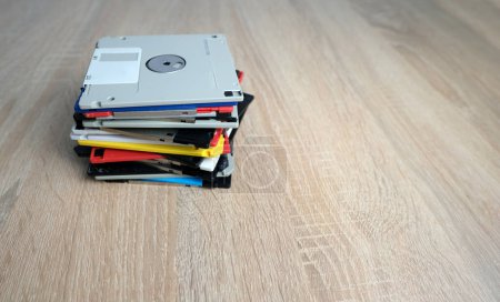 Foto de Dispositivos de almacenamiento de datos electrónicos retro vintage, de los años 80, 90 unidades flash dispersas sobre la mesa. Pila de disquetes, pendrive y disco duro en gris, negro, azul, amarillo, rojo, blanco - Imagen libre de derechos