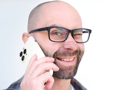 Photo for Positive charming young man in glasses uses modern phone, smiles, concept role of gadgets in everyday life, in business, Business Communication - Royalty Free Image