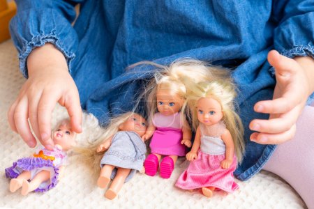 Téléchargez les photos : Interaction sociale surviennent lorsque les enfants s'engagent dans des scénarios de jeu de poupées collaboratif, fille, enfant joue mère-filles avec des poupées miniatures - en image libre de droit
