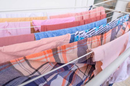 wet clothes of pink color hanging on clothes dryer, Laundry Routine and Household Chores, Efficient Management in home environment, lonely life