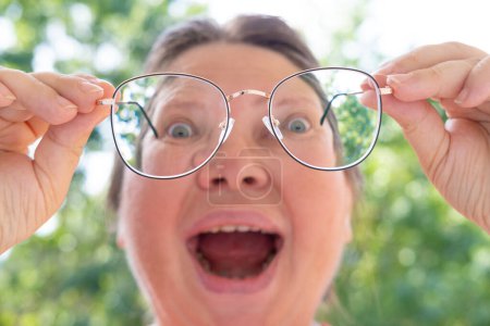 Photo for Surprised woman in glasses looks in surprise, funny joke, female joker laughs with mouth wide open, Physical and Emotional Release, expression of laughter and enjoyment may vary across societies - Royalty Free Image