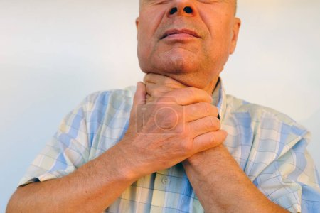 primer plano de las manos masculinas en el cuello, hombre carismático maduro sostiene la garganta, mayor de 60 años está enfermo, concepto de salud, tratamiento de diagnóstico Descripción general de la glándula tiroides, inflamación de la tiroides, pérdida de la voz