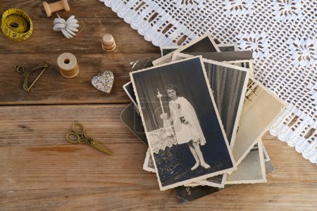 old family photographs, pictures from 1940, lace doily, home archive documents on vintage wooden table, concept of family tree, genealogy, memories, memory of ancestors, family tree, nostalgia