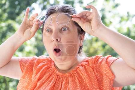 Photo for Woman's shocked expression with eyes wide open and startled look on face, raised glasses on forehead, surprised, shocked by news, event, Comedic Performance and Expression - Royalty Free Image