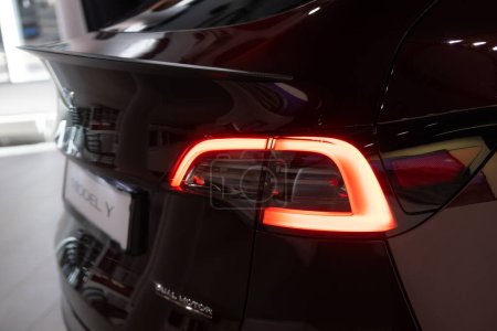 Foto de Luces traseras del coche Tesla modelo Y en color rojo cereza en Studio, vehículo eléctrico en sala de exposición, concepto de desarrollo de energía alternativa, marca Elon Musk company, Alemania - 2 de septiembre de 2023 - Imagen libre de derechos