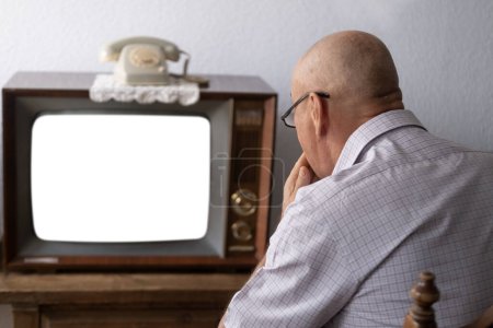 Foto de Senior, hombre viendo televisión, viejo tubo vintage 60s TV, maqueta en pantalla blanca vacía, streaming en línea y televisión, entretenimiento en el hogar, medios de comunicación y publicidad, tecnología retro - Imagen libre de derechos