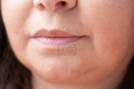 Téléchargez les photos : Gros plan partie visage, lèvres femme mature 55 ans, rides autour de la bouche, changements de peau liés à l'âge, procédures cosmétiques anti-âge - en image libre de droit