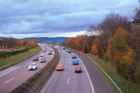 Foto de Los vehículos de pasajeros y mercancías viajan a lo largo de la autopista A5 en Alemania, con montañas Taunus en el fondo, red de transporte, tráfico de seguridad en la carretera, vida moderna de la ciudad - Imagen libre de derechos