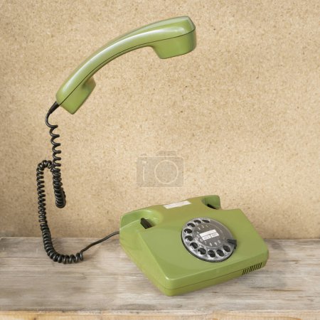 Photo for Old green Rotary Telephone with Disc Dial, phone handset levitates, flies in air, Secure Communication, Obsolete Technology, Retro Aesthetic 80s - Royalty Free Image