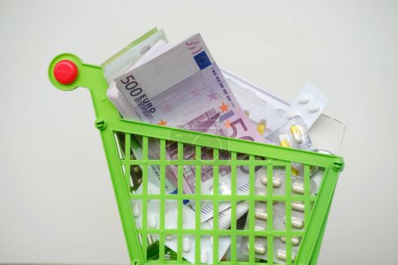 Photo for Medicines and pills in shopping cart, blister packs, medicine bottles, euro banknotes into shopping basket, concept Drug pharmacology and pharmacy delivery, accessibility of healthcare, medical ethics - Royalty Free Image
